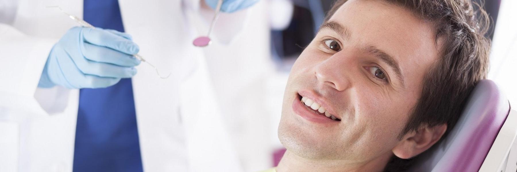 man smiling in dental office l dental implants new orleans la
