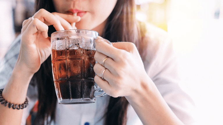A woman drinking soda from a cup with a straw in New Orleans