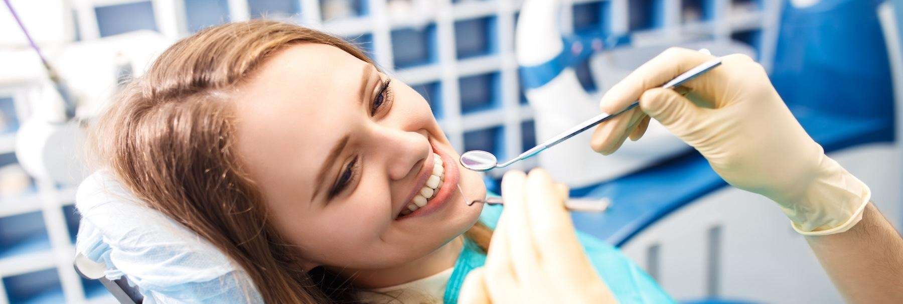 woman sitting in dentist exam chair | dentist new orleans