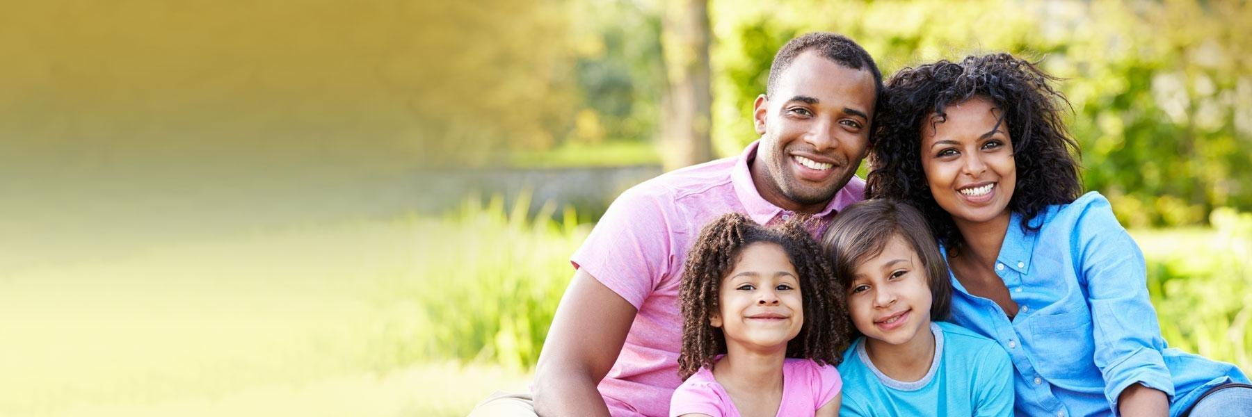 family of four hugging outside | gum disease new orleans 