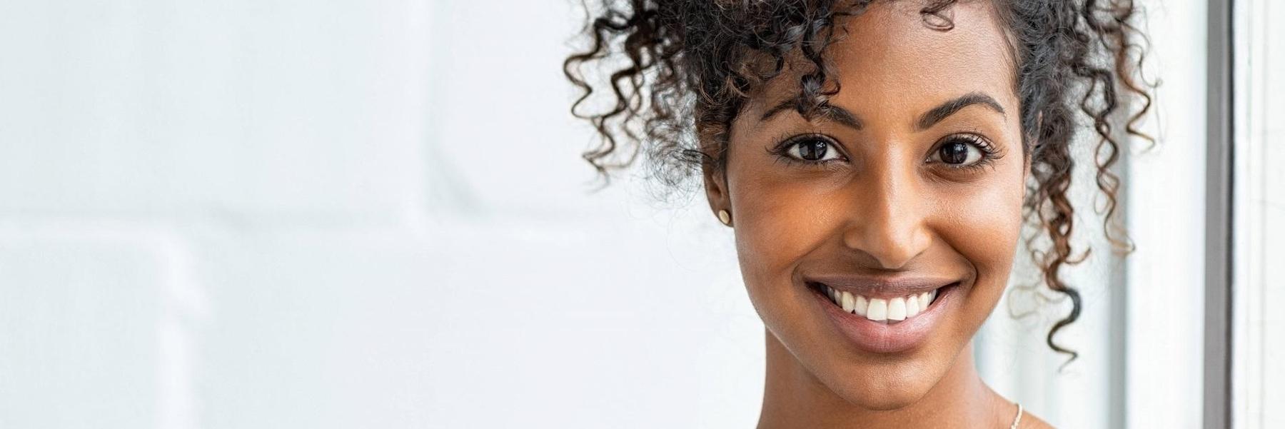woman with curly hair smiling l invisalign nola